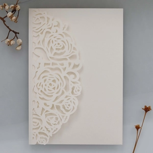 Détails des motifs de roses découpés au laser sur une carte d'invitation blanche