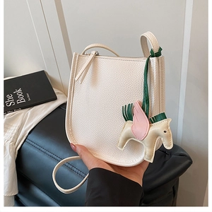 Detail of white litchi pattern leather bucket bag with horse charm and slim strap
