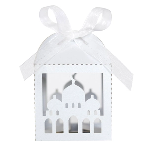 Macro detail of laser-cut mosque pattern and white ribbon on white favor box