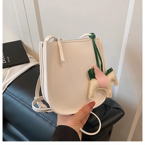 Detail of cream leather crossbody bag featuring a colorful Pegasus charm and zip closure