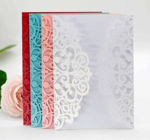 Detail view of laser-cut wedding invitations with intricate floral scroll patterns