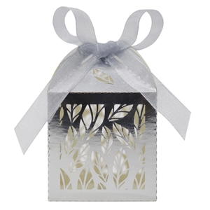 Detail of silver laser-cut wedding favor box with leaf pattern and elegant ribbon