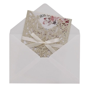 Detail of laser-cut glitter wedding invitation with white ribbon and floral card set