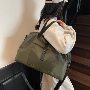 Army green large travel tote bag with shoulder strap shown carried by a model