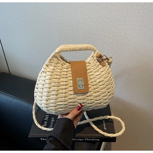 Detail of hand-woven straw bag with leather flap and metallic twist-lock closure