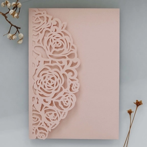 Détail de motifs de roses découpés au laser sur papier rose élégant pour faire-part