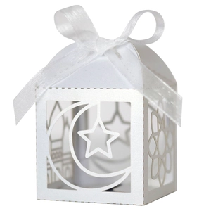 Detail of white laser-cut hollow gift box featuring moon and star patterns with a silk bow