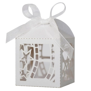 Detail of white laser-cut hollow gift box with elegant star pattern and ribbon
