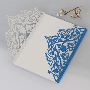 Detail of laser-cut glitter blue invitation card with elegant floral lace pattern