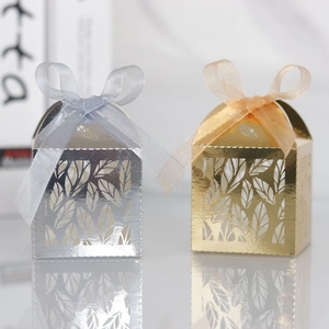 Detailed laser-cut leaf pattern on gold and silver wedding favor boxes with ribbon bows