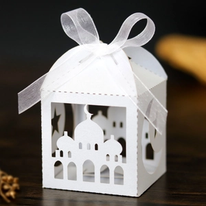 Laser-cut white Eid favor box with mosque and star patterns plus a white ribbon