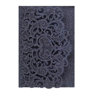 Detail of laser-cut glitter paper wedding invitation featuring intricate vine patterns