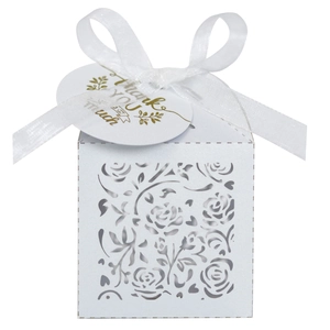 Macro detail of white laser-cut floral gift box with silk ribbon and gold thank you tag