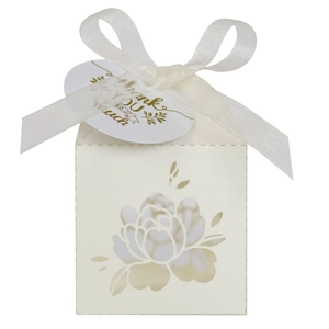 Detail of laser-cut hollow floral candy box with white ribbon and Thank You card