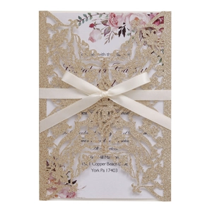 Golden glitter laser-cut butterfly wedding invitation with white floral card and ribbon