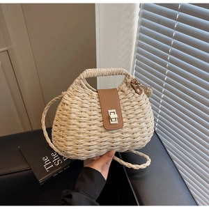 Detail view of woven straw bag featuring brown leather flap and silver metal twist lock
