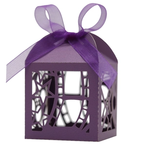 Macro shot of purple hollow-out gift box with laser-cut stars and matching silk ribbon bow