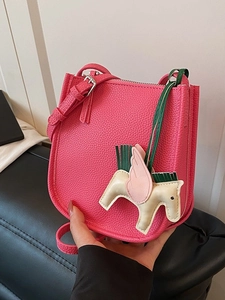Hot pink lychee leather bucket bag with a colorful winged pegasus charm and adjustable strap