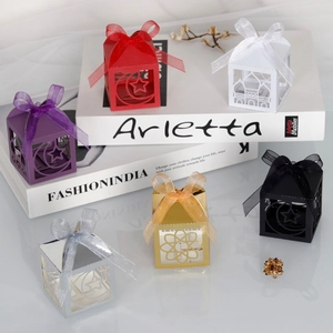 Macro view of laser-cut gift box with intricate star and moon patterns and satin ribbon