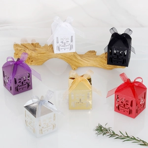 Detail of laser-cut candy boxes with mask patterns and ribbon bows in six various colors