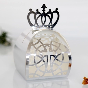 Detail of silver laser-cut crown favor box with intricate hollow patterns for wedding candy