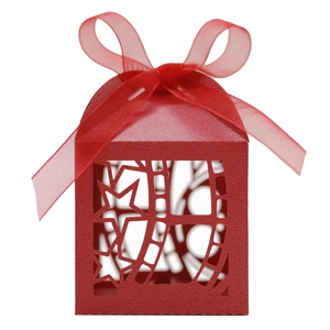 Close-up of red laser-cut candy box with star patterns and a matching organza ribbon bow