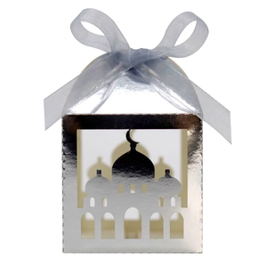 Close-up of silver laser-cut candy box with mosque silhouette and blue satin ribbon bow