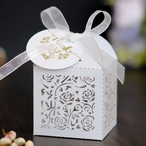 Close-up of white laser-cut rose gift box with Thank You tag and white ribbon bow