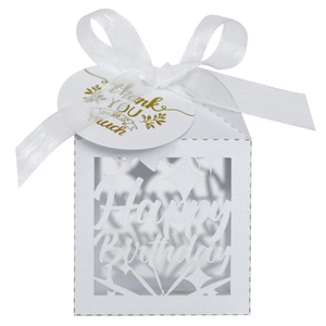 Detail of white laser-cut Happy Birthday candy box with ribbon and thank you tag