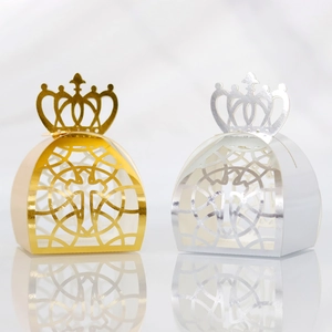 Close-up of laser-cut crown favor boxes in gold and silver finish with hollow patterns