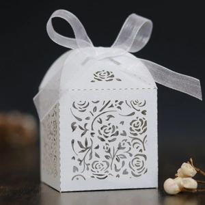Macro detail of laser-cut rose patterns on elegant white paper gift box with ribbon