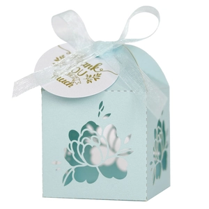 Detail of light blue laser-cut gift box with floral patterns and a thank you tag
