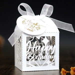 Close-up of laser-cut Happy Birthday candy box with white ribbon and thank you tag