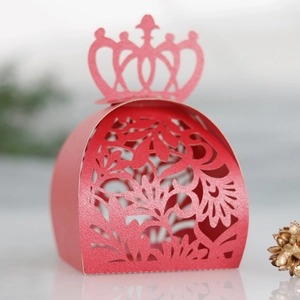 Vue macro d'une boîte à bonbons de mariage rouge découpée au laser avec couronne élégante