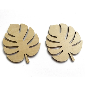 Two laser-cut Monstera leaf wooden coasters with natural wood grain on white background