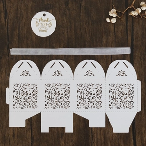 Flat lay of white laser-cut rose gift box template with thank you tag and ribbon