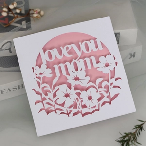 Détail d'une carte 'Love You Mom' découpée au laser avec motifs floraux