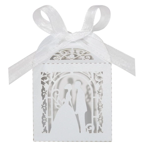 Detail of laser-cut pearl white wedding favor box with romantic couple silhouette and bow