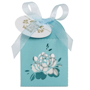 Detail of light blue laser-cut wedding favor box with silk ribbon and thank you tag