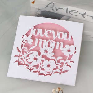 Détail de la carte 'Love You Mom' découpée au laser avec motif ajouré rose et blanc