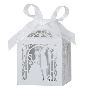 Detail of laser-cut white wedding favor box with bride and groom silhouette and ribbon