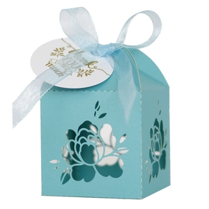 Close-up of laser-cut flower gift box with blue ribbon and Thank You gold tag