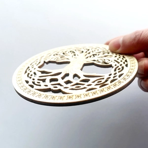 Handheld Tree of Life laser-cut wooden coaster with intricate geometric petal patterns