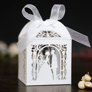 Elegant white laser-cut wedding favor box with bride groom silhouettes and silk ribbon