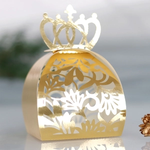 Détails de découpe laser florale et couronne sur boîte à bonbons dorée de mariage