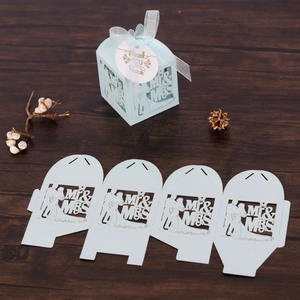 Detail of laser-cut wedding favor box in light blue with Mr & Mrs bride groom silhouette
