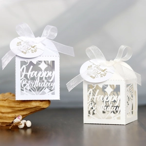 Detailed view of white laser-cut house gift boxes with Happy Birthday cutout and ribbon