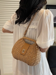Handcrafted straw woven crossbody bag with leather flap and metallic twist lock for beach vacations
