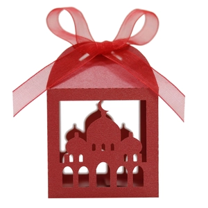 Close-up of laser-cut red paper candy box with mosque silhouette and satin ribbon