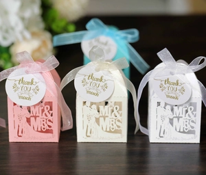 Close-up of laser-cut Mr & Mrs wedding favors boxes with ribbons and thank you tags